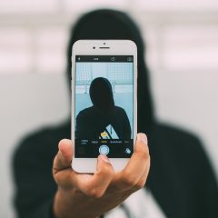 奥连界主编沈砚的侧脸工作照，深色针织衫、桌前摊着标注密密的条目清单，正在用笔核对「ao3链接」信息架构的修订记录